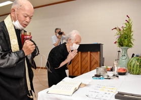 読経する山下幸雄さん(左)と焼香する石田多美枝さん=高橋地区コミュニティセンター 読経する山下幸雄さん(左)と焼香する石田多美枝さん=高橋地区コミュニティセンター