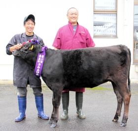 種牛の部で1等賞1席に輝いた「うえだ676」と上田伸也さん(右)=みかた畜産事業所 種牛の部で1等賞1席に輝いた「うえだ676」と上田伸也さん(右)=みかた畜産事業所