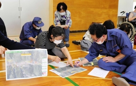 集落の防災マップで避難経路などを確認する住民ら=養父市出合 集落の防災マップで避難経路などを確認する住民ら=養父市出合