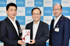 嶋公治教育長(右)と関貫久仁郎市長(左)に寄付目録を手渡す樫本孝彦社長=豊岡市役所 嶋公治教育長(右)と関貫久仁郎市長(左)に寄付目録を手渡す樫本孝彦社長=豊岡市役所