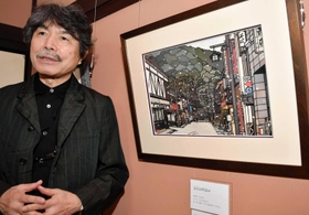 雪がちらつく出石の町並みを描いた作品を紹介する久保修さん=出石史料館 雪がちらつく出石の町並みを描いた作品を紹介する久保修さん=出石史料館