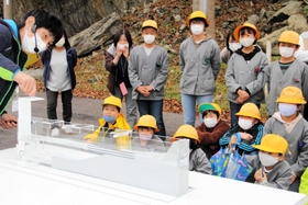 新温泉土木事務所の職員が実験装置を使い、地震で津波が起きるメカニズムなどを児童に語った出前講座=香美町香住区余部 新温泉土木事務所の職員が実験装置を使い、地震で津波が起きるメカニズムなどを児童に語った出前講座=香美町香住区余部