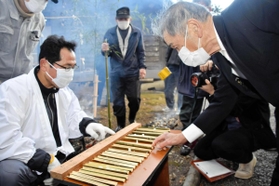 竹筒に入った粥(かゆ)の量を確かめる氏子ら=折杉神社 竹筒に入った粥(かゆ)の量を確かめる氏子ら=折杉神社
