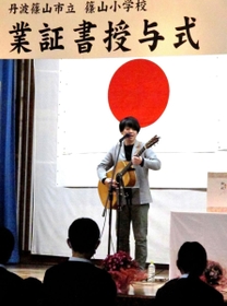 サプライズライブで、ギターの弾き語りをする「ちめいど」の中越雄介さん=丹波篠山市立篠山小 サプライズライブで、ギターの弾き語りをする「ちめいど」の中越雄介さん=丹波篠山市立篠山小