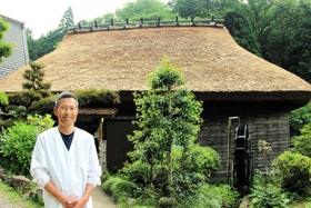 茅葺き屋根の葺き替えを終えた建物の前に立つ「いわや」の店主・岩本和也さん=丹波篠山市火打岩 茅葺き屋根の葺き替えを終えた建物の前に立つ「いわや」の店主・岩本和也さん=丹波篠山市火打岩