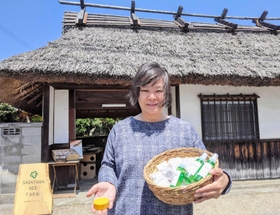 長屋門の前で、自慢のせっけんなどを手にした「ささやまビーファーム」の松村社長=丹波篠山市北新町 長屋門の前で、自慢のせっけんなどを手にした「ささやまビーファーム」の松村社長=丹波篠山市北新町