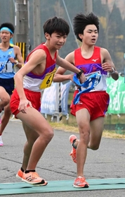 男子・氷上の2区大木輝星選手(右)からたすきを受け取る3区臼井樹生選手=豊岡市日高町 男子・氷上の2区大木輝星選手(右)からたすきを受け取る3区臼井樹生選手=豊岡市日高町