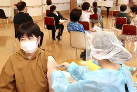 ワクチンの接種を受ける施設職員(手前)。後方では経過観察のため職員が待機した=グランはりま ワクチンの接種を受ける施設職員(手前)。後方では経過観察のため職員が待機した=グランはりま