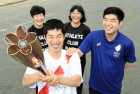 7月3日に聖火のトーチを披露する(手前左下から反時計回りに)野入邦弘さん、兄直輝さん、母恵美香さん、アスリートクラブいなみ野の藤本悦子代表=サン・スポーツランドいなみ 7月3日に聖火のトーチを披露する(手前左下から反時計回りに)野入邦弘さん、兄直輝さん、母恵美香さん、アスリートクラブいなみ野の藤本悦子代表=サン・スポーツランドいなみ