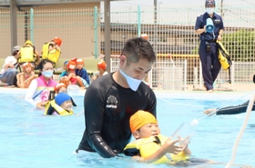 加古川海上保安署員(中央)らと水に浮く練習をする園児=川西こども園 加古川海上保安署員(中央)らと水に浮く練習をする園児=川西こども園