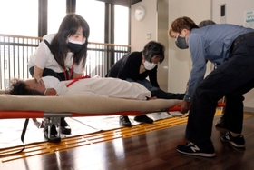 毛布を使い負傷者の運び方を確認する参加者=加古川市加古川町寺家町、市総合福祉会館 毛布を使い負傷者の運び方を確認する参加者=加古川市加古川町寺家町、市総合福祉会館