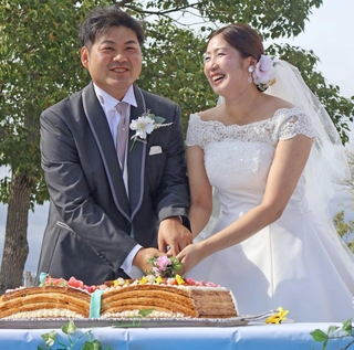 ケーキに入刀する新郎の中井拓さん(左)と新婦の杏奈さん=稲美町加古、加古大池