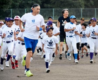 野球教室で子どもたちとランニングするイチローさん(左)と松井秀喜さん(奥)=2日、石川県七尾市