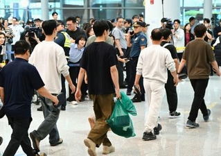 12日、韓国の仁川国際空港に到着した、米国で拘束されていた労働者ら(共同)