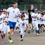 野球教室で子どもたちとランニングするイチローさん(左)と松井秀喜さん(奥)=2日、石川県七尾市