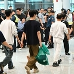 12日、韓国の仁川国際空港に到着した、米国で拘束されていた労働者ら(共同)