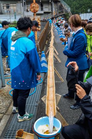 高知県仁淀川町で行われた、流しそうめんの距離に挑むイベント=25日午前