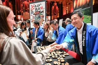 「ジャパンエキスポ」で来場者に天むすを配る名古屋市の広沢一郎市長(右端)=25日、オーストラリア・シドニー(共同)