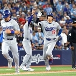 ブルージェイズ戦の7回、2ランを放ち三塁コーチとタッチを交わすドジャース・大谷(右)=トロント(共同)