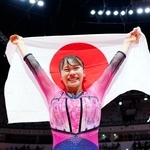 体操の世界選手権女子種目別の床運動で優勝し、日の丸を掲げる杉原愛子=25日、ジャカルタ(共同)