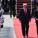 26日、マレーシア・クアラルンプールの空港に到着したトランプ米大統領(中央)と共に歩くマレーシアのアンワル首相(右)(AP=共同)
