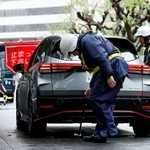 米大使館周辺で、通行車両の検問を実施する警察官=26日午前、東京・赤坂