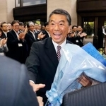 宮城県知事選で6選を果たし、職員と握手する村井嘉浩知事=27日午前、県庁