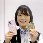 成田空港に帰国し、金メダルと手元に戻ったスマートフォンを手に笑顔を見せるレスリングの藤波朱理=27日
