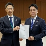 秋田県の鈴木健太知事(左)から要望書を手渡された小泉防衛相=28日午前、防衛省