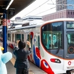 JR桜島駅でミャクミャク電車を見送る駅員ら=29日午前、大阪市此花区