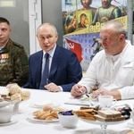 ウクライナ侵攻で負傷したロシア兵らが療養する病院を訪れたプーチン大統領(中央)=29日、モスクワ(タス=共同)