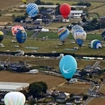 佐賀インターナショナルバルーンフェスタが開幕し、浮かび上がる熱気球=30日午前、佐賀市(共同通信社ヘリから)