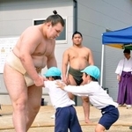 園児と相撲を取る安青錦。奥は今年完成した屋内の稽古場=30日、福岡県久留米市