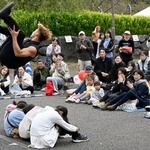 「大道芸ワールドカップin静岡2025」で、座った子どもたちの上を宙返りで飛び越えるアーティスト=31日午後、静岡市