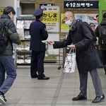 名鉄上小田井駅で情報提供を呼びかける高羽奈美子さんの夫悟さん(右)=2月、名古屋市