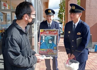 コンビニ店長強盗殺人事件の現場近くで、商業施設の利用客に情報提供を呼びかける石川県警大聖寺署の小坂裕署長(右)ら=1日午前、石川県加賀市