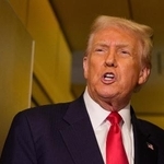 10月30日、米大統領専用機内で記者団に話すトランプ米大統領(ゲッティ=共同)