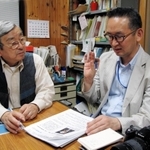 脱線事故について尹記者(右)から取材を受ける遺族の浅野さん=尼崎市内