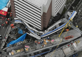 マンションに天井部分から激突した2両目。車体の一部は、4分の1以下の幅に圧縮された=4月25日午後4時40分 マンションに天井部分から激突した2両目。車体の一部は、4分の1以下の幅に圧縮された=4月25日午後4時40分