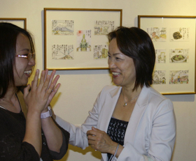 夫の絵手紙を紹介する展覧会会場で、訪れた人と談笑する石井房江さん(右)=東京都中央区、東邦アート(撮影・永見将人) 夫の絵手紙を紹介する展覧会会場で、訪れた人と談笑する石井房江さん(右)=東京都中央区、東邦アート(撮影・永見将人)