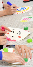 紙皿カスタネット【1】紙皿を半分に折って、外側に絵を描く【2】紙皿の内側に、セロハンテープでペットボトルのキャップを二つ貼り付ける。折り畳んだときにちゃんと重なるよう位置を調整=神戸新聞社(撮影・後藤亮平) 紙皿カスタネット【1】紙皿を半分に折って、外側に絵を描く【2】紙皿の内側に、セロハンテープでペットボトルのキャップを二つ貼り付ける。折り畳んだときにちゃんと重なるよう位置を調整=神戸新聞社(撮影・後藤亮平)