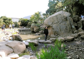 水辺の周囲を巡ることができる池泉回遊式庭園。三宅玉峰さん(中央)は「景観の変化を楽しんで」と話す=洲本市山手3 水辺の周囲を巡ることができる池泉回遊式庭園。三宅玉峰さん(中央)は「景観の変化を楽しんで」と話す=洲本市山手3