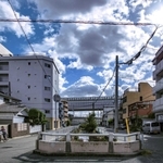 現在の久寿川(中央)は、地下水路になって高速道路と国道43号(奥)を越える。今津公設市場は国道南側にあった=今津水波町、今津久寿川町(撮影・三津山朋彦)
