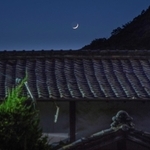 如意輪寺の石段下に椎名麟三が9~15歳まで過ごした旧居が今もたたずむ。夕暮れ時、屋根瓦の向こうに月が浮かんだ=姫路市書写(撮影・三津山朋彦)
