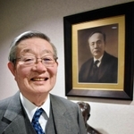 カネボウの創始者で祖父の武藤山治の写真の前で話す武藤治太さん=大阪市内