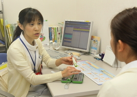 ペン型の注射器を示しながら、成長ホルモン補充療法について説明する看護師(右は患者役の職員)=加古川市神野町神野(撮影・辰巳直之) ペン型の注射器を示しながら、成長ホルモン補充療法について説明する看護師(右は患者役の職員)=加古川市神野町神野(撮影・辰巳直之)