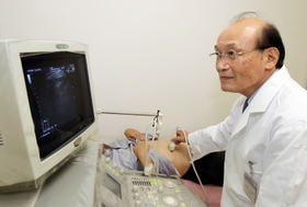 超音波検査の機器を扱う奥野忠雄医師(患者はモデル)=兵庫県明石市東仲ノ町(撮影・山口登) 超音波検査の機器を扱う奥野忠雄医師(患者はモデル)=兵庫県明石市東仲ノ町(撮影・山口登)