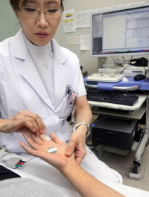 指に電極を貼る金谷貴子医師。パソコン画面に神経反応が波形で表れる=神戸市中央区籠池通4(撮影・辰巳直之) 指に電極を貼る金谷貴子医師。パソコン画面に神経反応が波形で表れる=神戸市中央区籠池通4(撮影・辰巳直之)