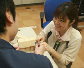 家の模型を組み立てる作業療法に付き添う岩本昌子さん(右、患者役は病院職員)=兵庫県たつの市新宮町光都1 家の模型を組み立てる作業療法に付き添う岩本昌子さん(右、患者役は病院職員)=兵庫県たつの市新宮町光都1