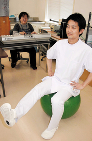 運動療法のイメージ。音楽療法士の演奏に合わせ、バランスボールを使って運動する(モデルは理学療法士)=いずれも尼崎市南塚口町6 運動療法のイメージ。音楽療法士の演奏に合わせ、バランスボールを使って運動する(モデルは理学療法士)=いずれも尼崎市南塚口町6